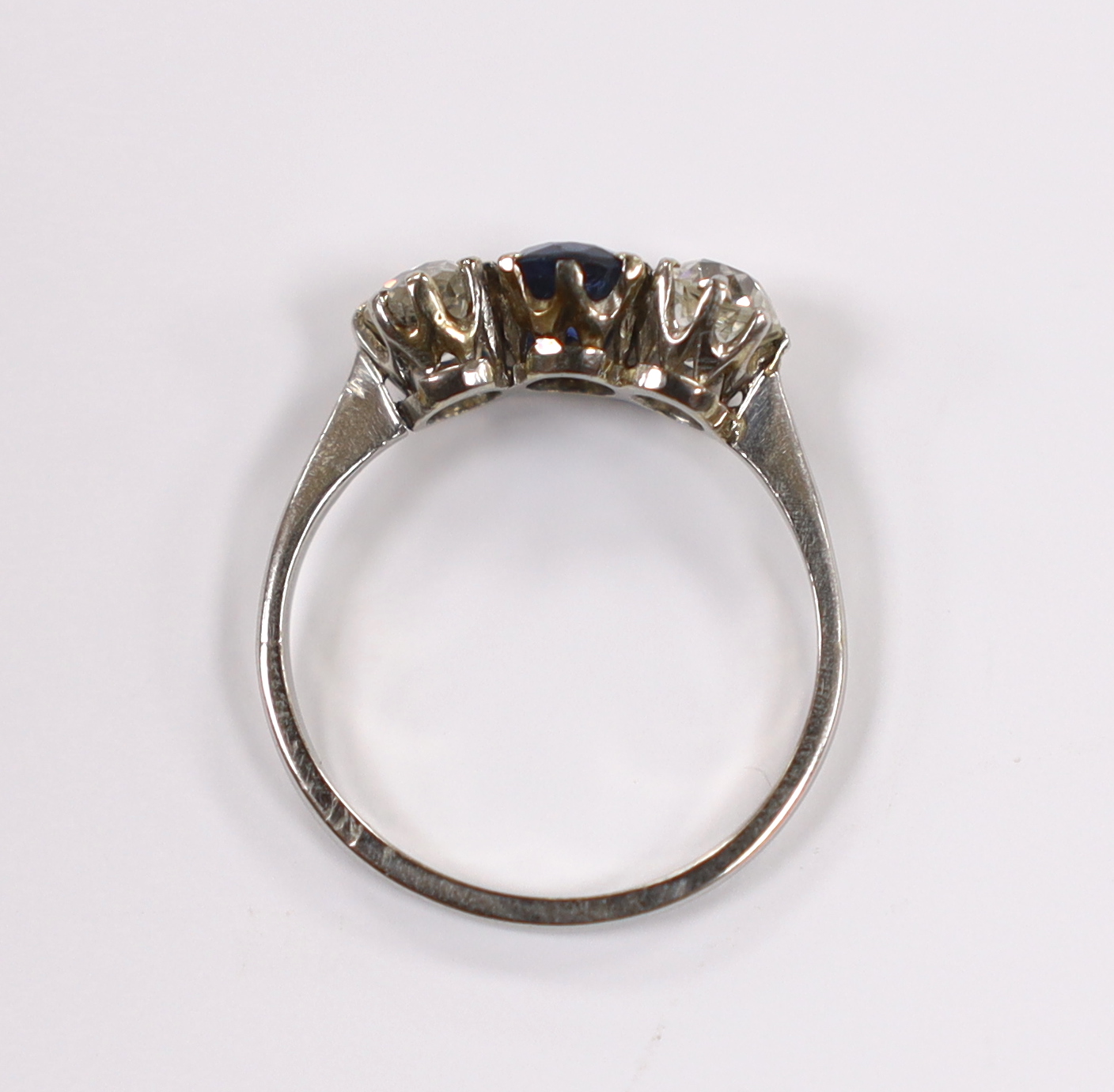 An early to mid 20th century white metal (stamped plat), single stone sapphire and two stone diamond set ring, size M, gross weight 2.7 grams.